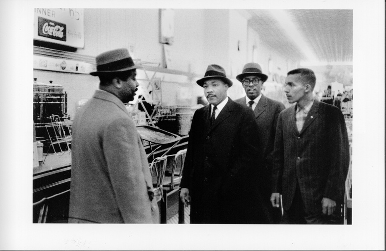 From left to right: Reverend Ralph Abernathy, Dr. Martin Luther King, Reverend Douglas Moore and an unidentified black man standing in a store.
