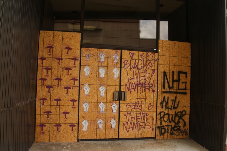 A mural depicting raised "power" fists and the words "black lives matter," "say their names," and "all power to the people."